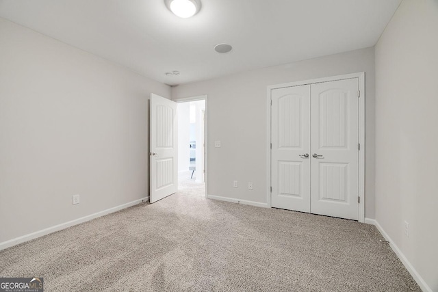 unfurnished bedroom with carpet, baseboards, and a closet