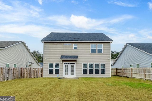 rear view of property with a lawn and a fenced backyard