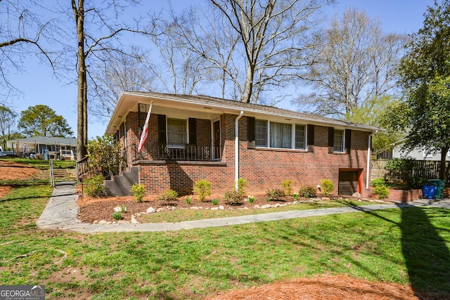 view of front of house featuring brick siding, a front lawn, and fence