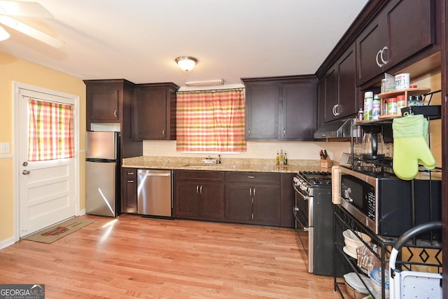 2780 Eastfield Rd SE, Smyrna, GA 30080 - kitchen with light wood-type flooring, stainless steel appliances, under cabinet range hood, a sink, and dark brown cabinetry