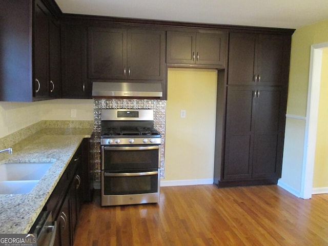 2780 Eastfield Rd SE, Smyrna, GA 30080 - kitchen featuring range hood, light stone countertops, wood finished floors, appliances with stainless steel finishes, and a sink