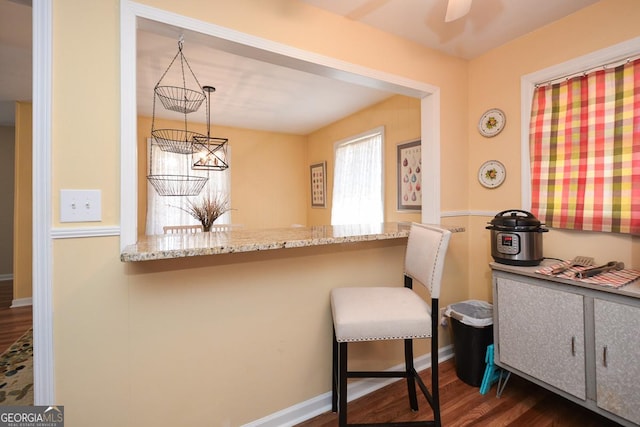 2780 Eastfield Rd SE, Smyrna, GA 30080 - kitchen with dark wood-style flooring, a peninsula, a breakfast bar area, and light stone counters