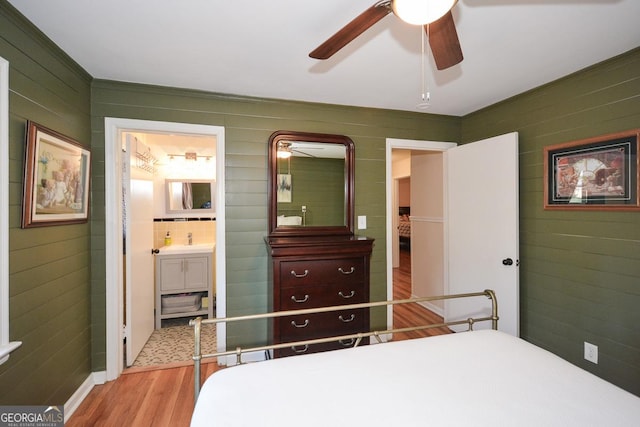 bedroom featuring a ceiling fan, ensuite bath, and wood finished floors