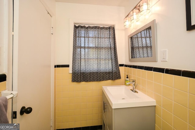 bathroom featuring a wainscoted wall, vanity, and tile walls