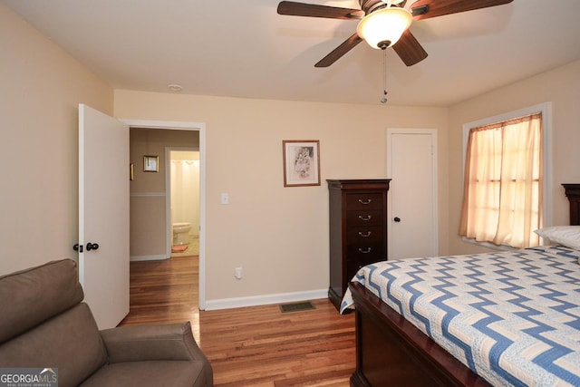 bedroom featuring visible vents, ceiling fan, baseboards, and wood finished floors