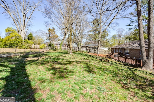 view of yard with a wooden deck and a fenced backyard