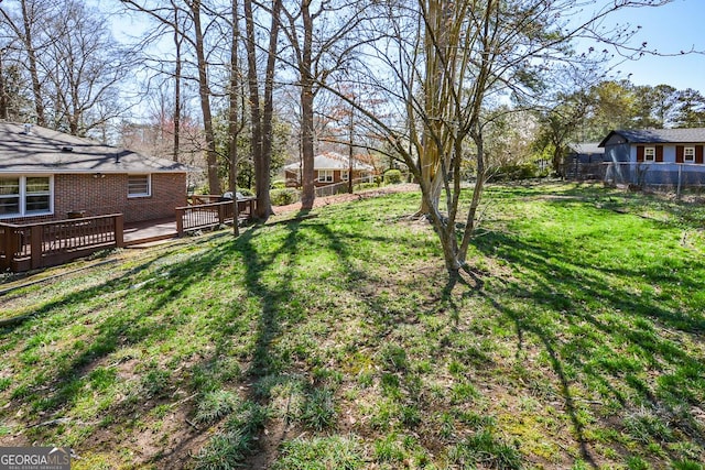 view of yard featuring fence and a wooden deck