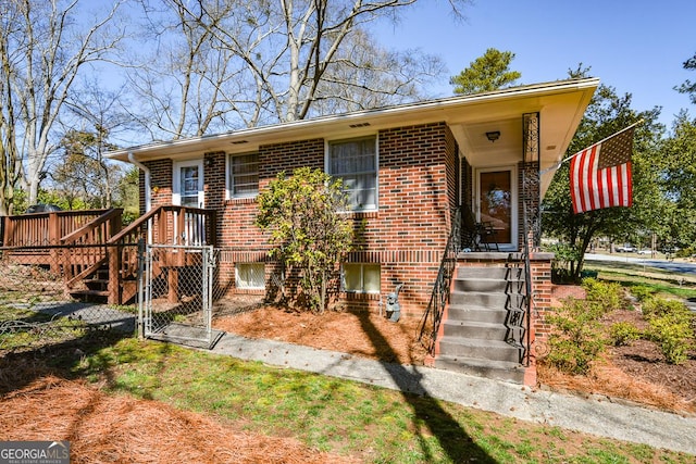 view of front of house featuring brick siding and a gate