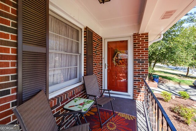 entrance to property with brick siding and visible vents