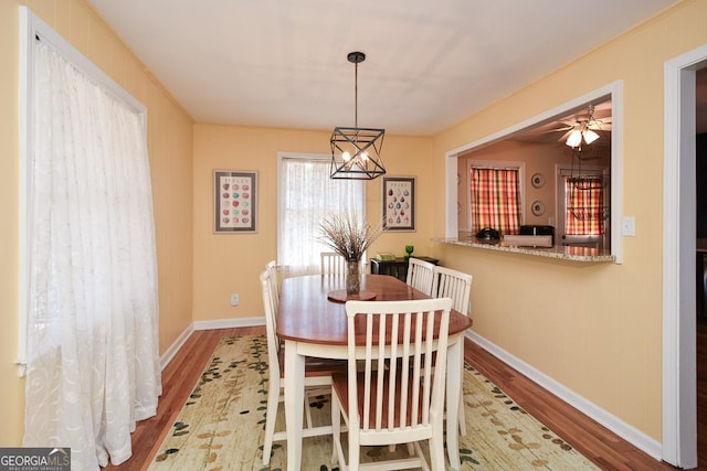 dining area featuring a notable chandelier, wood finished floors, and baseboards