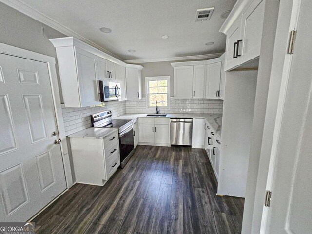 kitchen with visible vents, a sink, decorative backsplash, stainless steel appliances, and crown molding