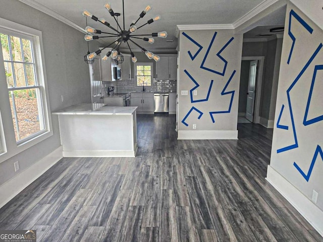 kitchen with decorative backsplash, dark wood-type flooring, appliances with stainless steel finishes, crown molding, and a notable chandelier