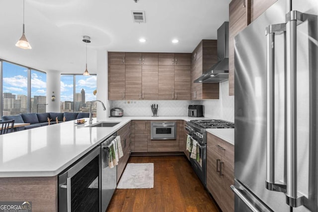 kitchen with beverage cooler, a sink, premium appliances, dark wood-style floors, and wall chimney exhaust hood