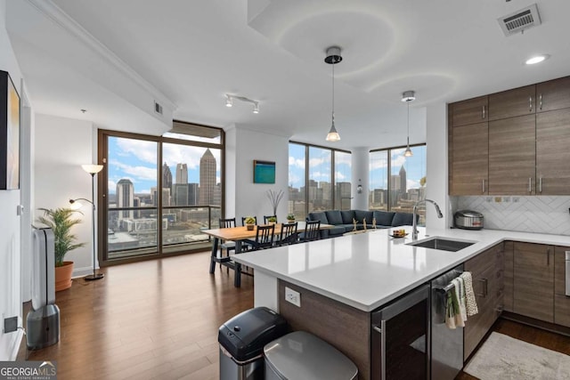 kitchen with a city view, expansive windows, visible vents, and a sink