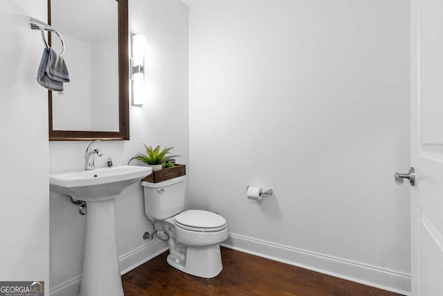 bathroom featuring toilet, wood finished floors, and baseboards