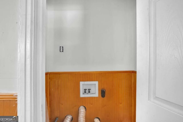 laundry area featuring a wainscoted wall, wooden walls, washer hookup, and laundry area