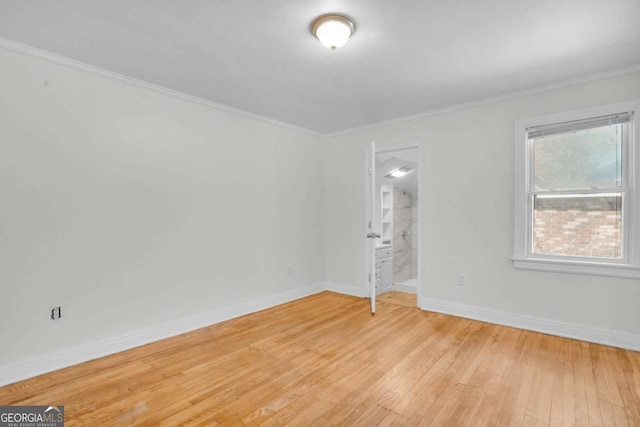 unfurnished room with light wood-style flooring, baseboards, and ornamental molding