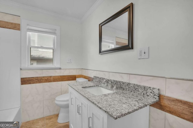 half bath with vanity, ornamental molding, tile walls, toilet, and tile patterned floors