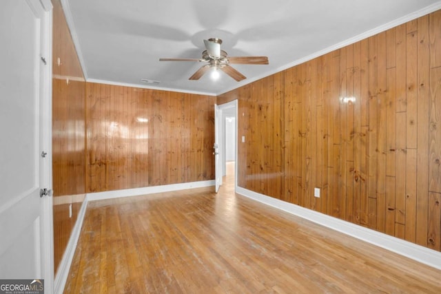 unfurnished room featuring a ceiling fan, crown molding, baseboards, and wood finished floors