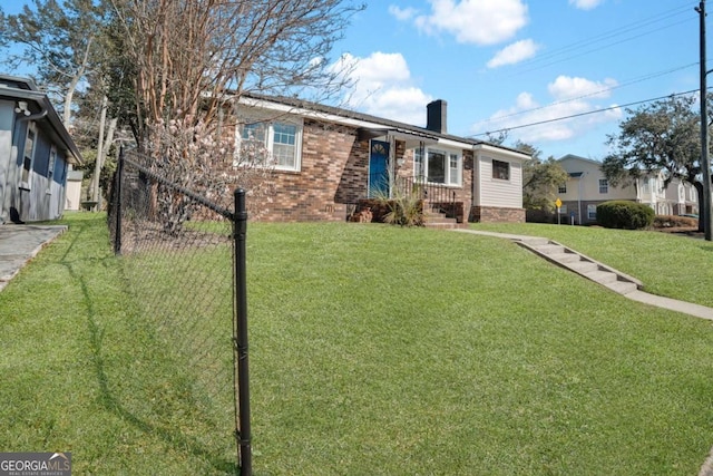 single story home with brick siding, a chimney, and a front yard