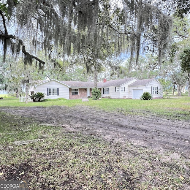 ranch-style house with a front yard, an attached garage, and a chimney