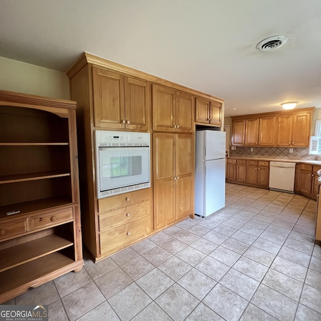 kitchen with visible vents, brown cabinets, backsplash, white appliances, and light tile patterned flooring