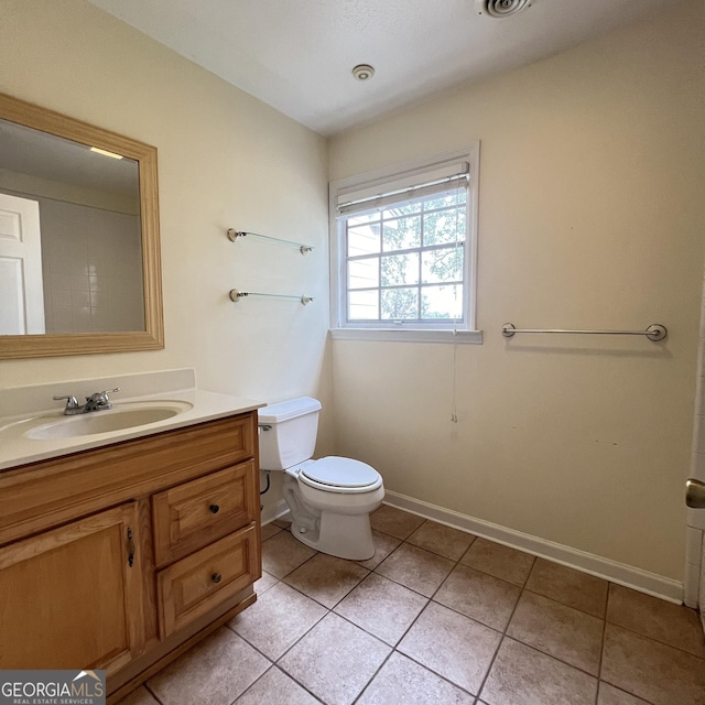 bathroom featuring tile patterned flooring, toilet, vanity, and baseboards