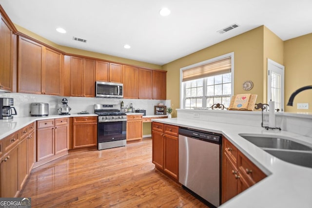 kitchen featuring decorative backsplash, visible vents, and appliances with stainless steel finishes