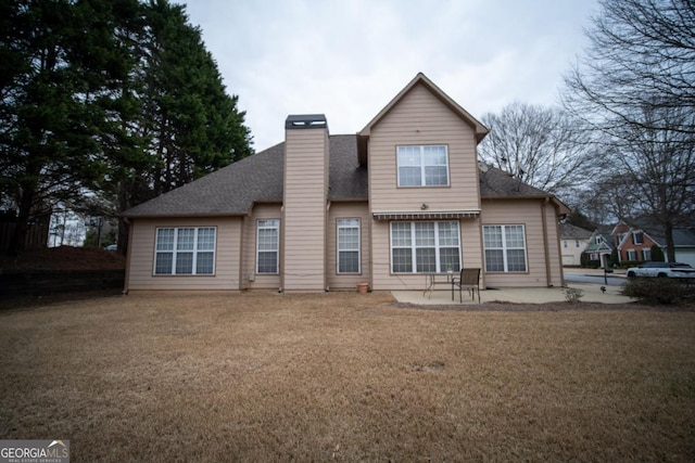 back of house featuring a shingled roof, a yard, a patio area, and a chimney