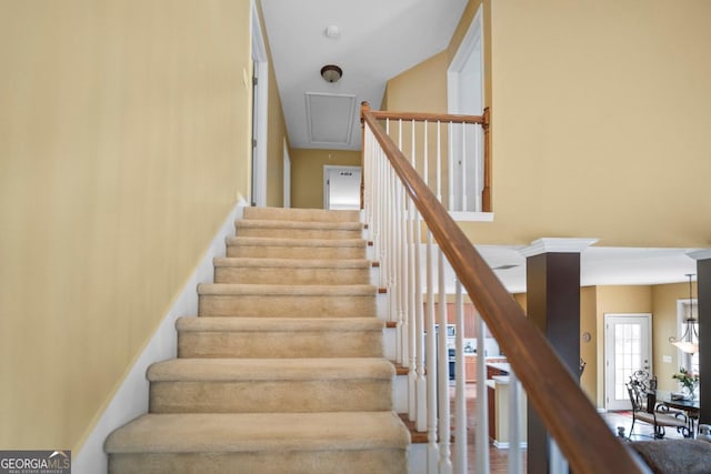 staircase featuring attic access and a high ceiling