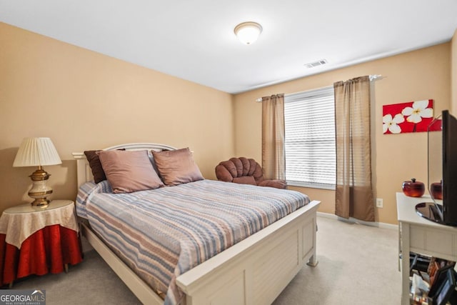 bedroom featuring baseboards, visible vents, and light carpet