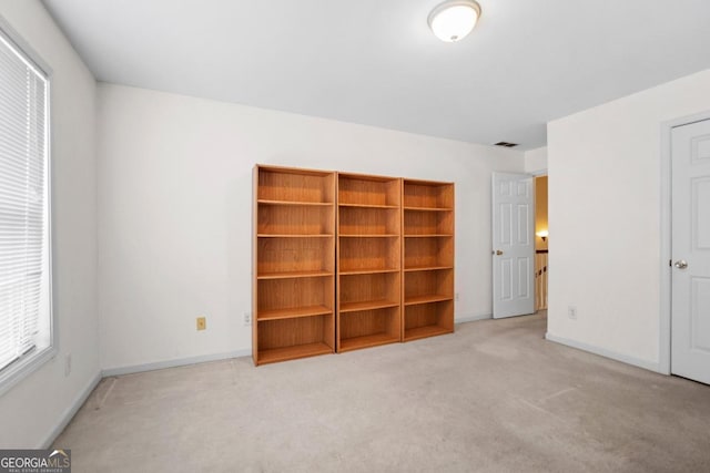 unfurnished bedroom with carpet flooring, baseboards, and visible vents