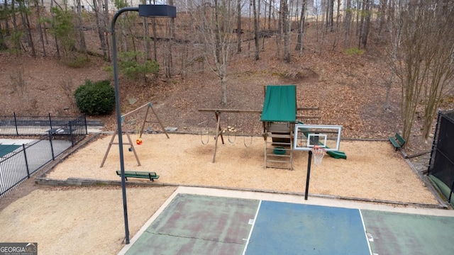 view of sport court featuring playground community and fence