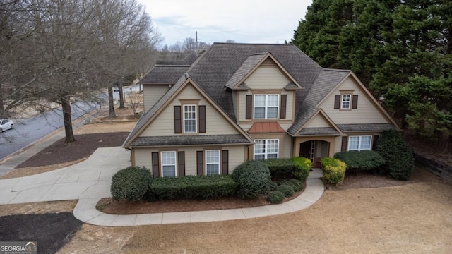 view of front facade with concrete driveway and a shingled roof