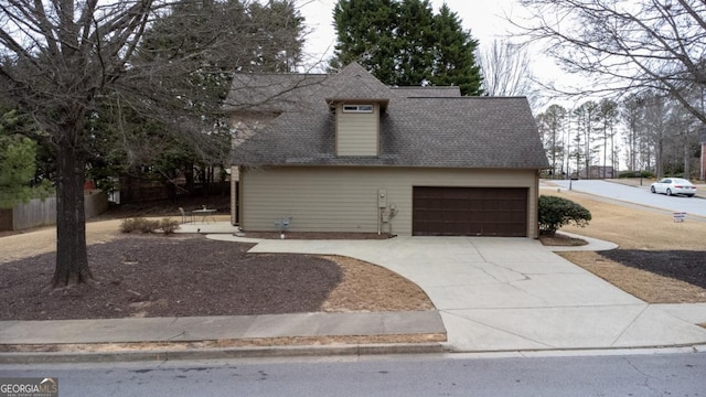 view of front of house featuring a garage, driveway, and a shingled roof