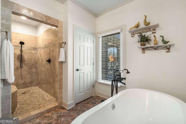 bathroom with baseboards, tiled shower, a soaking tub, brick floor, and crown molding