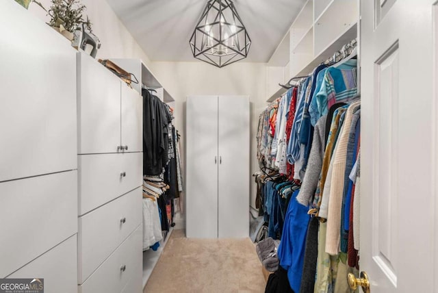 walk in closet featuring a notable chandelier and carpet