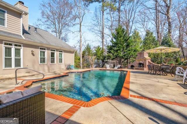 view of pool featuring fence, a patio area, a fenced in pool, and an outdoor stone fireplace