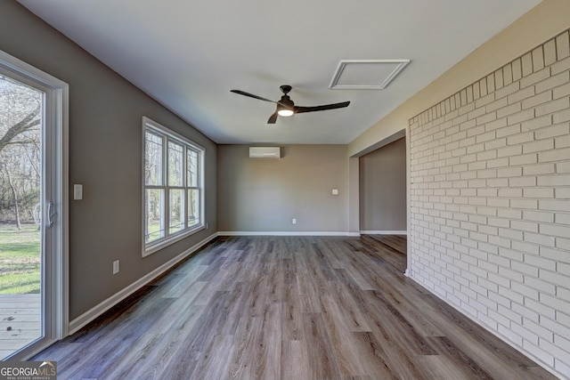 spare room with dark wood finished floors, brick wall, a wall mounted AC, and baseboards