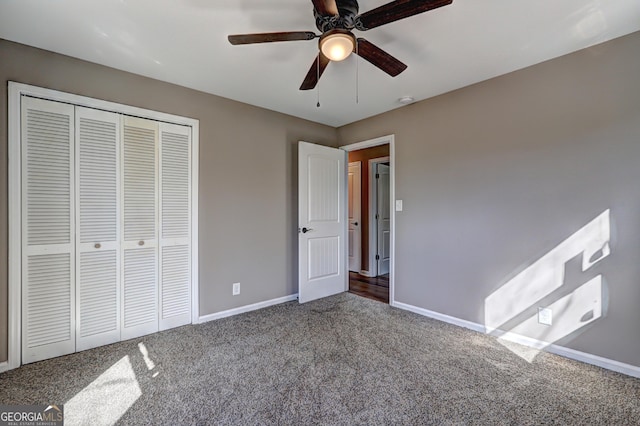 unfurnished bedroom with a closet, baseboards, carpet floors, and ceiling fan