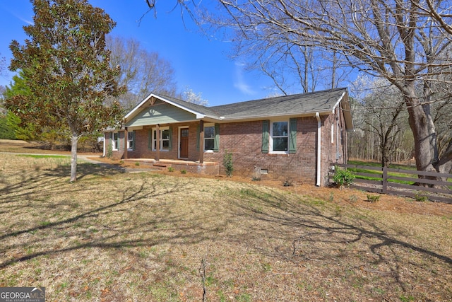 ranch-style home with crawl space, a front yard, brick siding, and fence