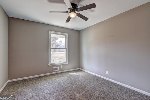 carpeted empty room featuring visible vents, baseboards, and ceiling fan