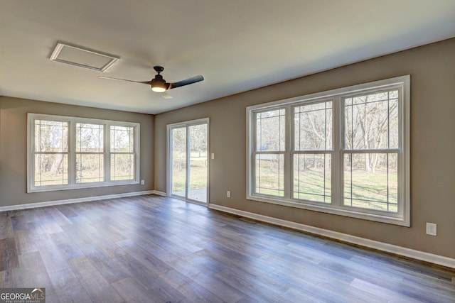 empty room with baseboards, dark wood-type flooring, and a ceiling fan