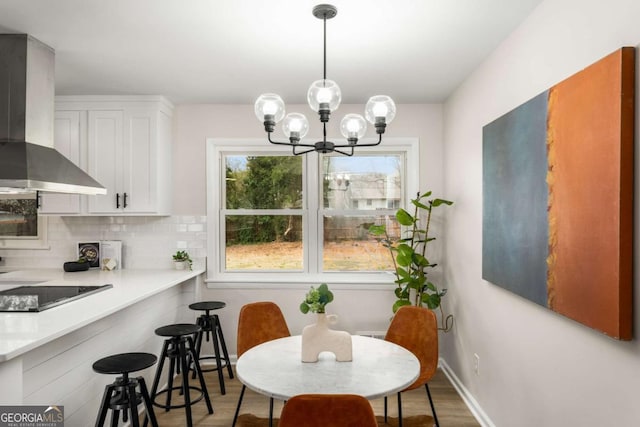 dining space with baseboards, a notable chandelier, and wood finished floors