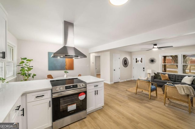 kitchen featuring white cabinets, a peninsula, electric stove, and exhaust hood