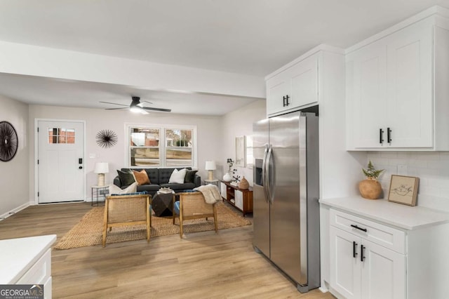 kitchen featuring light countertops, white cabinets, light wood-style floors, and stainless steel refrigerator with ice dispenser