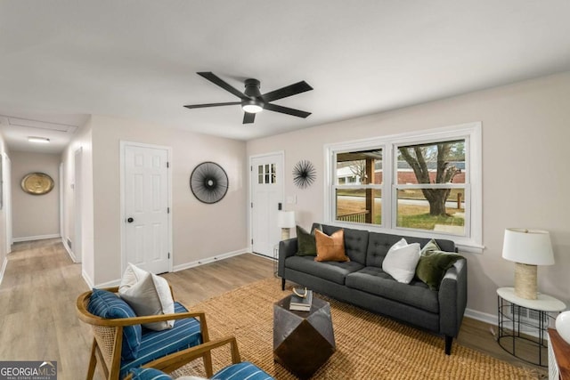 living room with baseboards, wood finished floors, and a ceiling fan