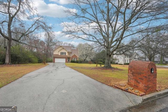 view of front facade featuring driveway and a front yard