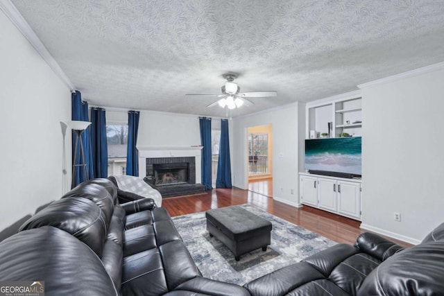 living room with dark wood-type flooring, a brick fireplace, and ornamental molding