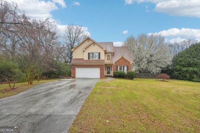 traditional-style house with fence, driveway, a front lawn, a garage, and brick siding